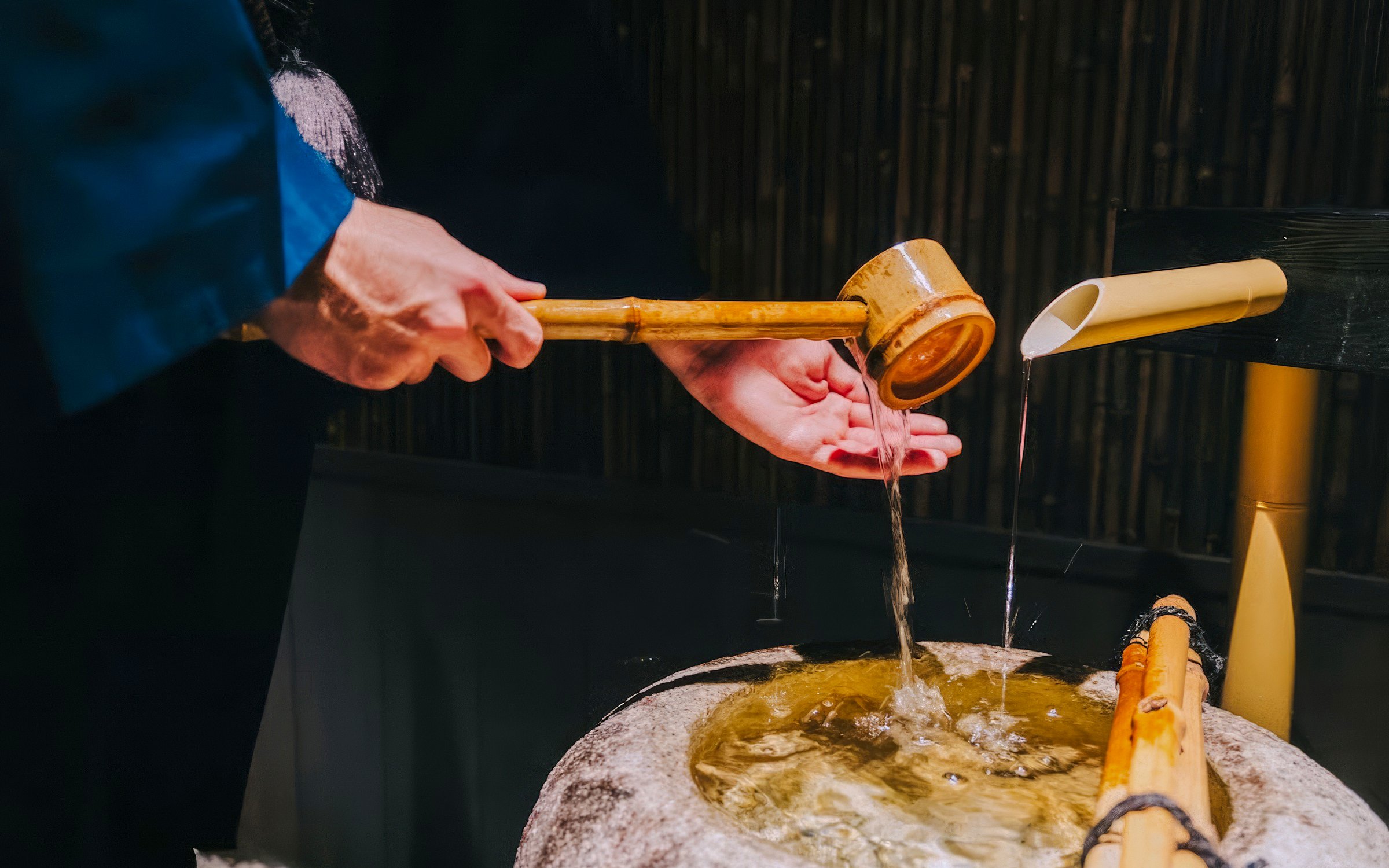 Purifying hands with water from a bamboo ladle before entering the tea room.