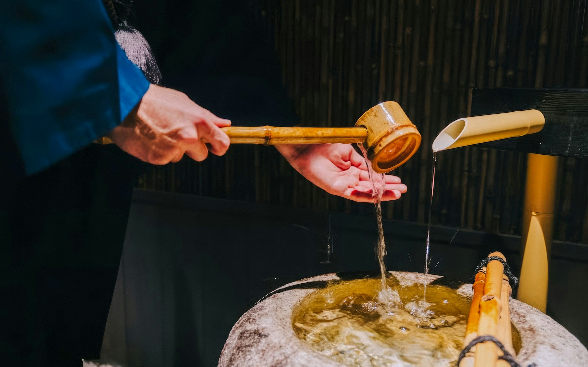 Purifying hands with water from a bamboo ladle before entering the tea room.