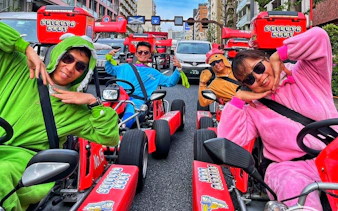 Go-kart riders in costumes on Shibuya streets during guided tour in Tokyo.