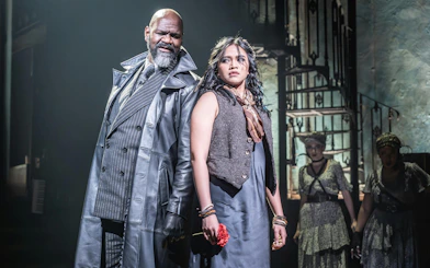Stage scene from Hadestown in West End with two main actors in dramatic pose.