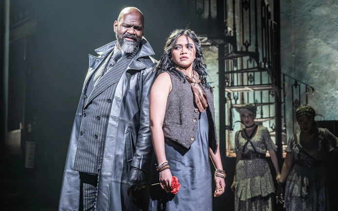 Stage scene from Hadestown in West End with two main actors in dramatic pose.