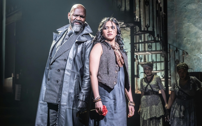 Stage scene from Hadestown in West End with two main actors in dramatic pose.