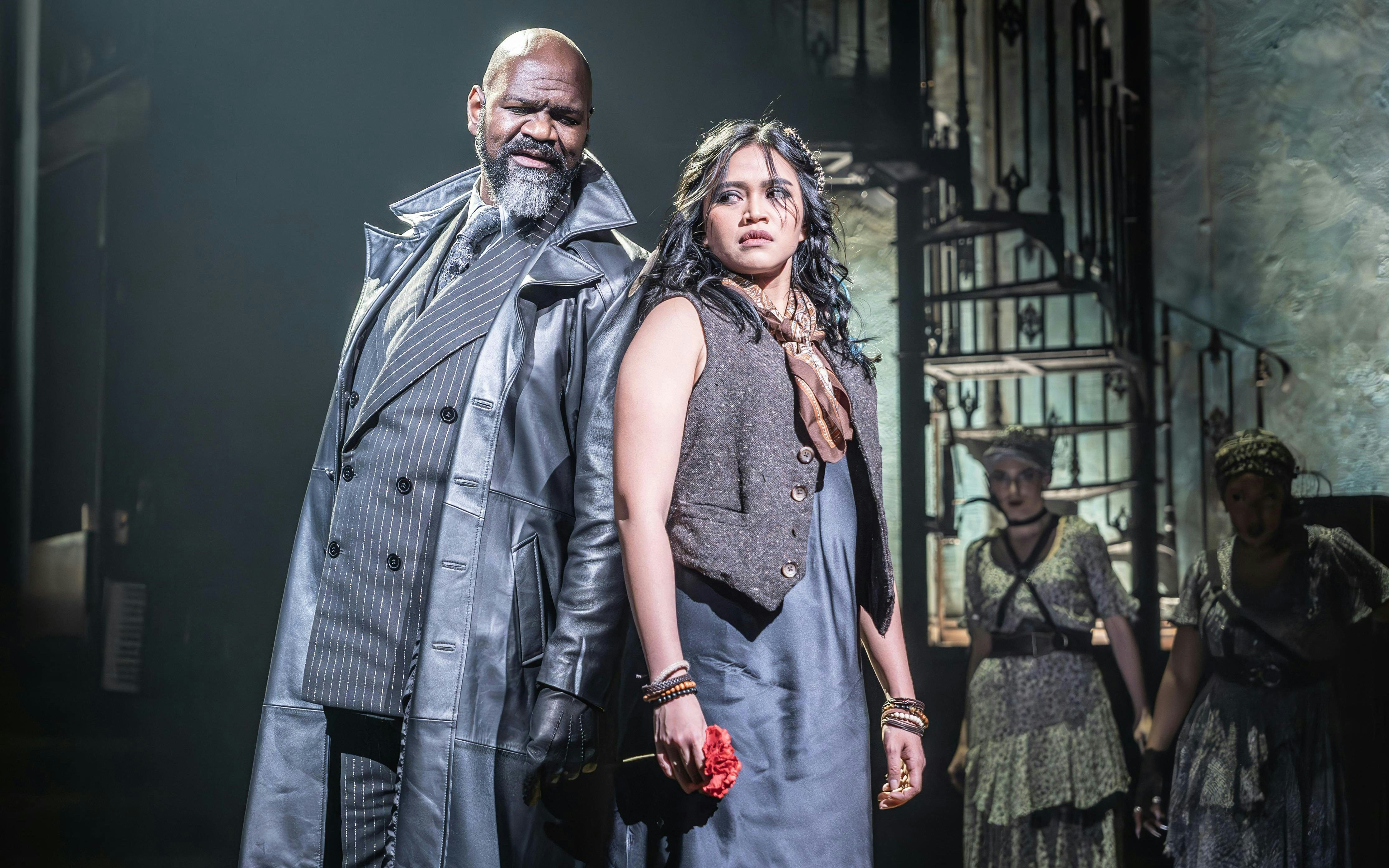 Stage scene from Hadestown in West End with two main actors in dramatic pose.