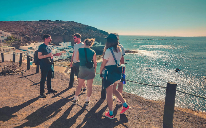 Group of tourists overlooking Playa del Confital during Red Canyon Tour.