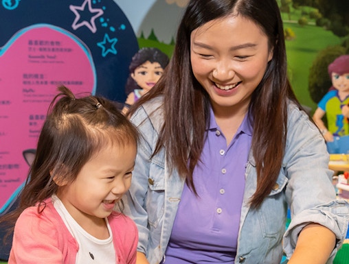 Child and adult building with LEGO bricks at Legoland Hong Kong.