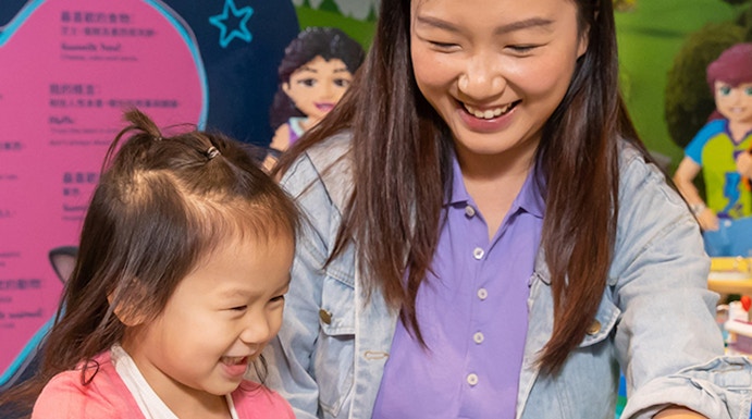 Child and adult building with LEGO bricks at Legoland Hong Kong.