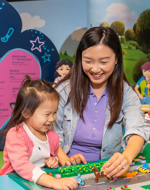 Child and adult building with LEGO bricks at Legoland Hong Kong.