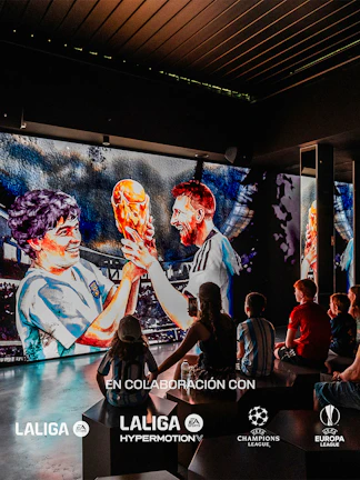 Visitors watching a football legends mural at Legends: The Home of Football Museum.