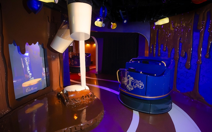 Cadbury World ride with chocolate-themed decor and milk pouring display.
