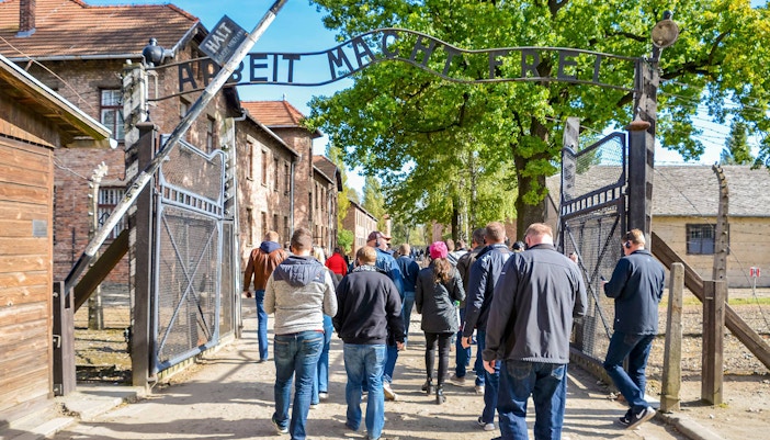 Auschwitz entrance with visitors on a Krakow day tour from Warsaw by train.