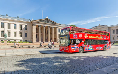 Red double-decker bus in front of Oslo University on a City Sightseeing Hop-On Hop-Off tour.