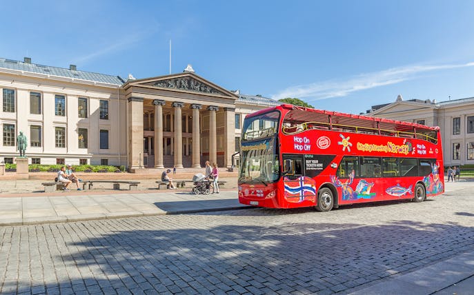 Red double-decker bus in front of Oslo University on a City Sightseeing Hop-On Hop-Off tour.