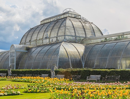 Victorian glasshouse and colorful tulip garden at Kew Gardens, London.