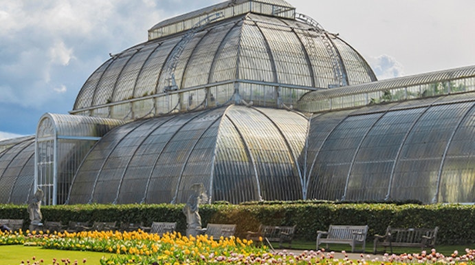 Victorian glasshouse and colorful tulip garden at Kew Gardens, London.