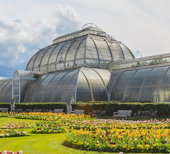 Victorian glasshouse and colorful tulip garden at Kew Gardens, London.
