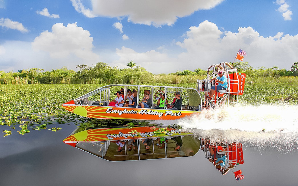 Airboat tour at Everglades Holiday Park with passengers enjoying the ride through wetlands.