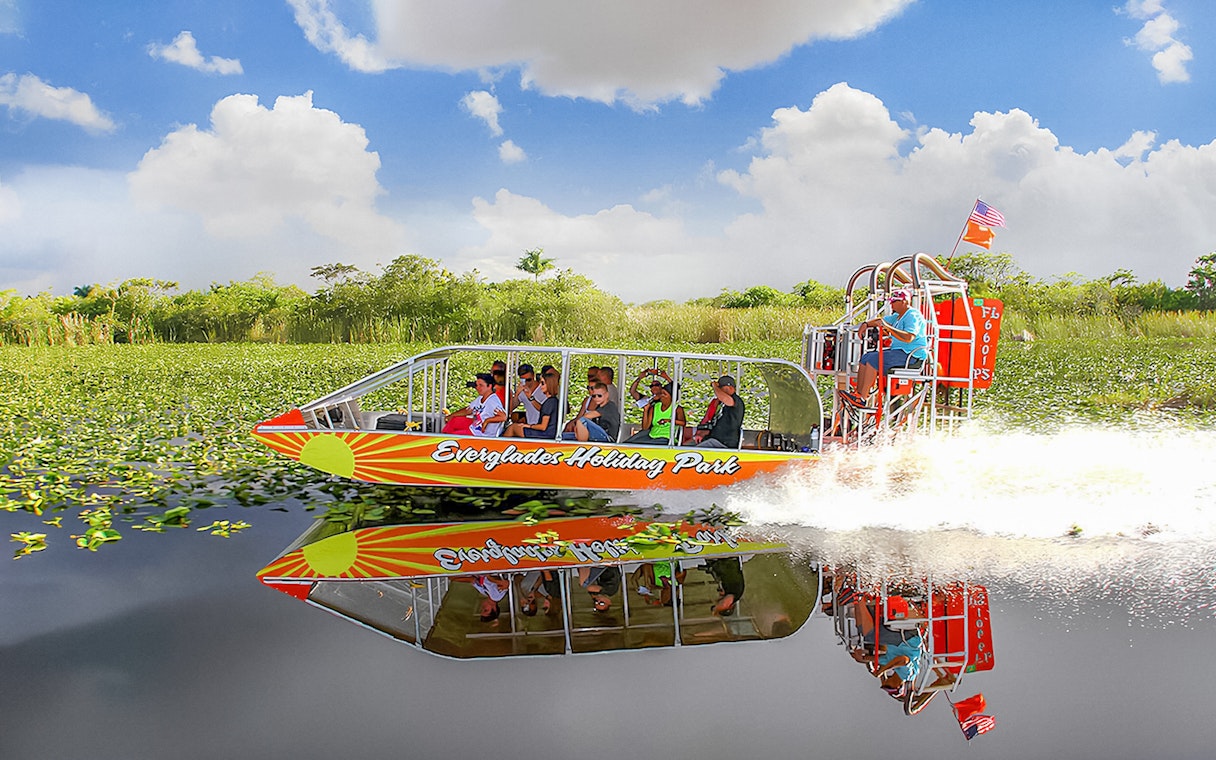 Airboat tour at Everglades Holiday Park with passengers enjoying the ride through wetlands.