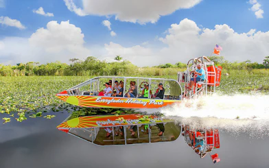 Airboat tour at Everglades Holiday Park with passengers enjoying the ride through wetlands.