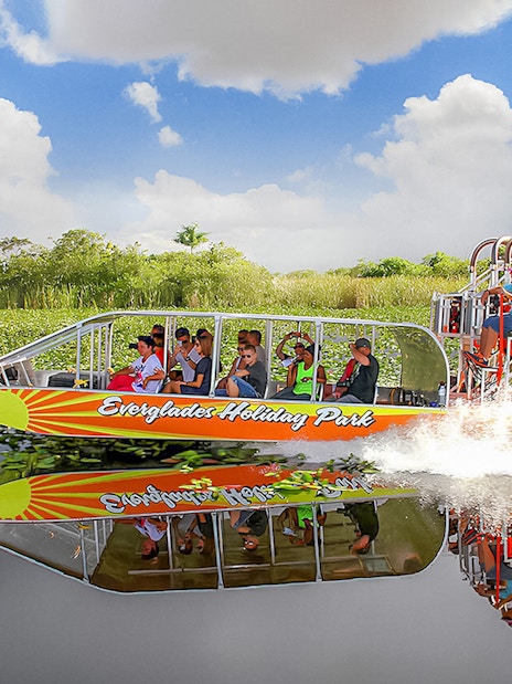 Airboat tour at Everglades Holiday Park with passengers enjoying the ride through wetlands.