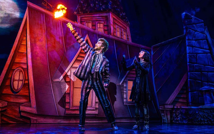 Stage scene from Beetlejuice show in Brisbane with characters on a rooftop.