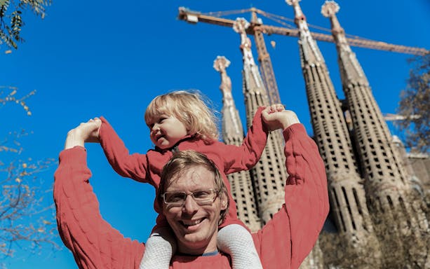 Family exploring Sagrada Familia in Barcelona, Spain, with intricate architectural details in the background.
