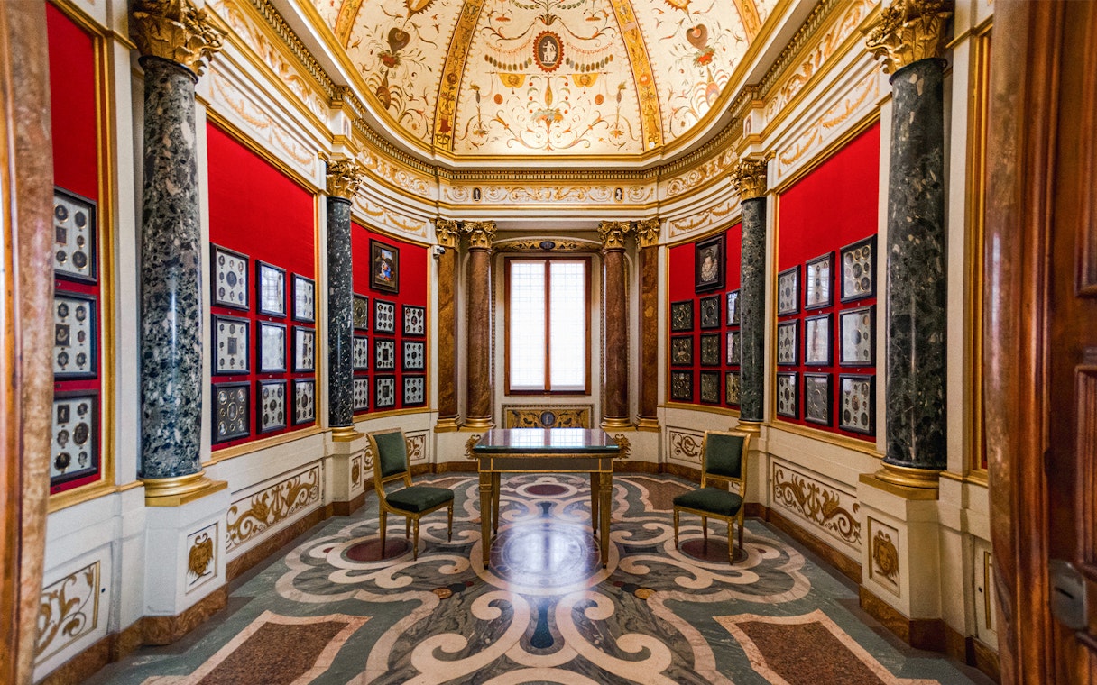 Art exhibits in a decorated room at the Uffizi Gallery, Florence, Italy.