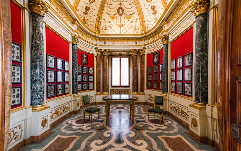 Art exhibits in a decorated room at the Uffizi Gallery, Florence, Italy.
