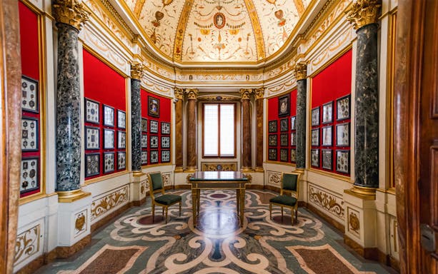 Art exhibits in a decorated room at the Uffizi Gallery, Florence, Italy.