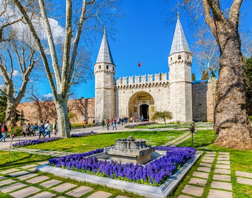 Topkapi Palace courtyard with tourists exploring historic architecture in Istanbul.