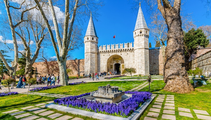 Topkapi Palace courtyard with tourists exploring historic architecture in Istanbul.