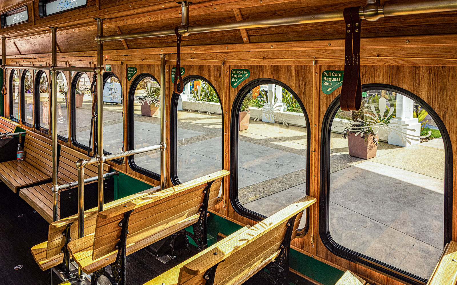 Interiors of I-Ride Trolley with wooden benches and arched windows in Orlando.