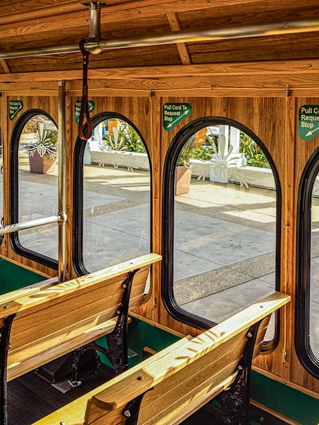 Interiors of I-Ride Trolley with wooden benches and arched windows in Orlando.