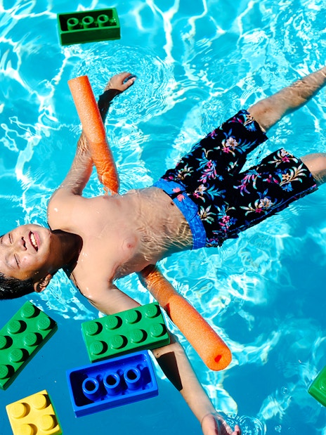Child floating in pool with large LEGO bricks at Water Playground, Legoland New York.