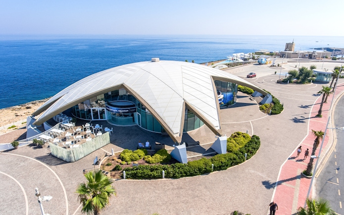 Aerial view of Malta National Aquarium with ocean backdrop.