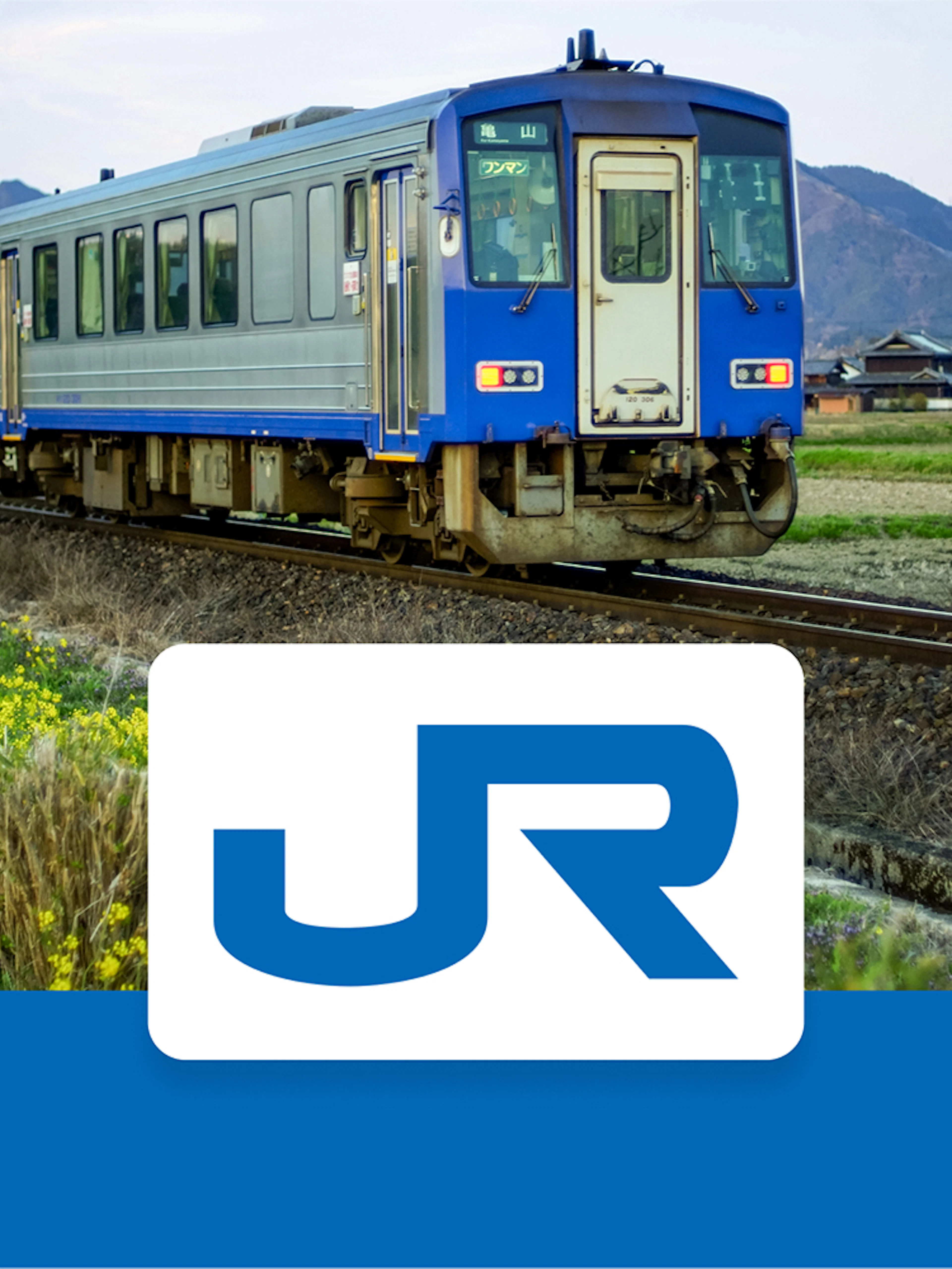 JR-West train traveling through rural Kansai with mountains in the background.