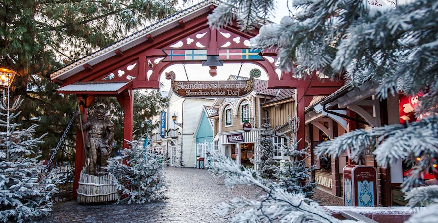Scandinavian village entrance with snow-covered trees at Europa Park.