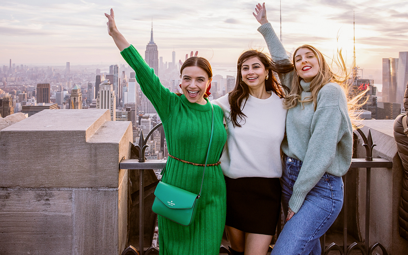Visitors enjoying the view from Top of the Rock Observation Deck, New York City skyline in background.