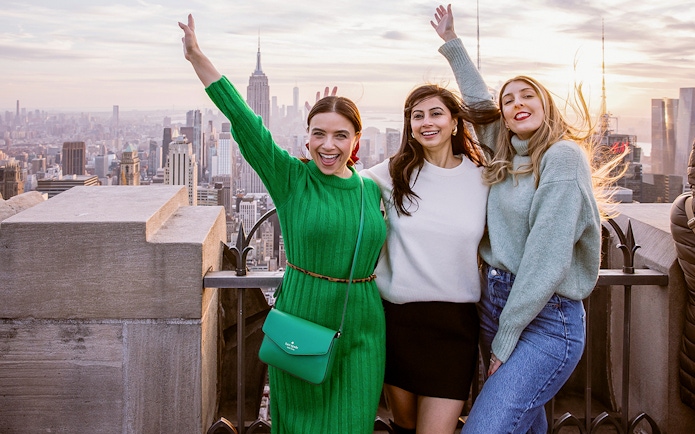 Visitors enjoying the view from Top of the Rock Observation Deck, New York City skyline in background.