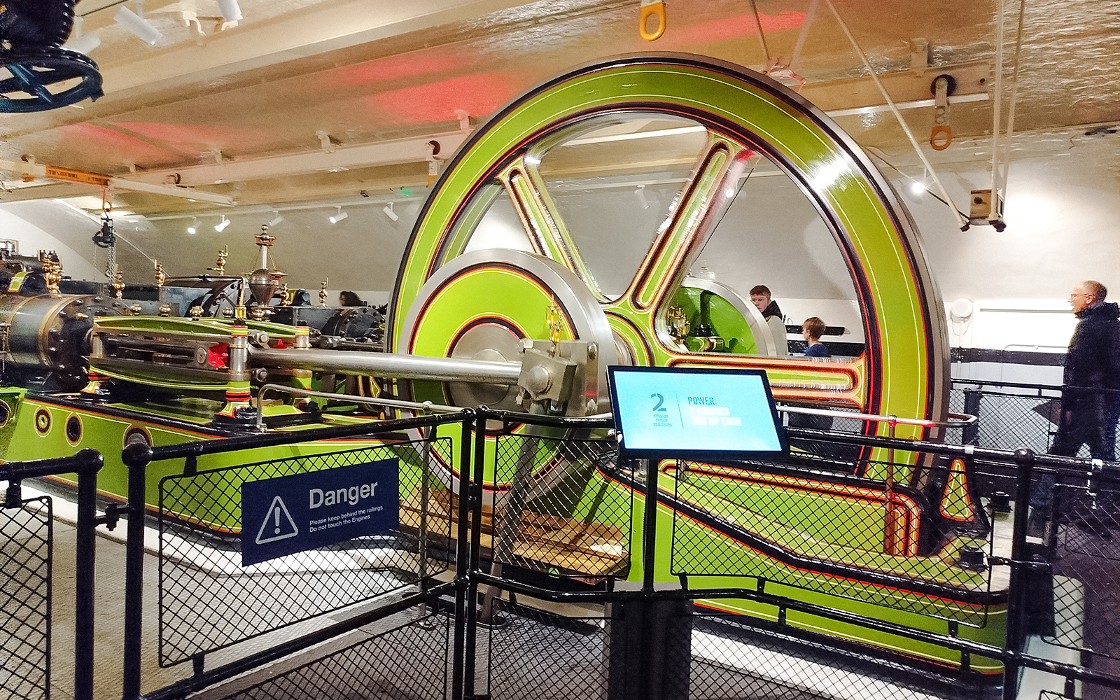 Engine room machinery at Tower Bridge, London, with visitors observing.