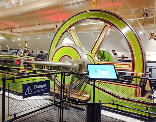 Engine room machinery at Tower Bridge, London, with visitors observing.