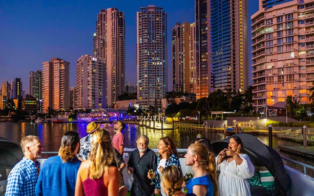 Guests enjoying a dinner cruise with city skyline views, Gold Coast.