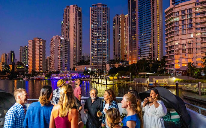 Guests enjoying a dinner cruise with city skyline views, Gold Coast.