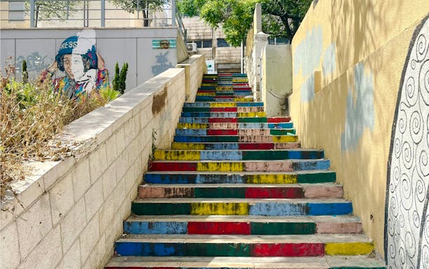 Colorful stairs on Rainbow Street, Amman, Jordan, with vibrant wall art.