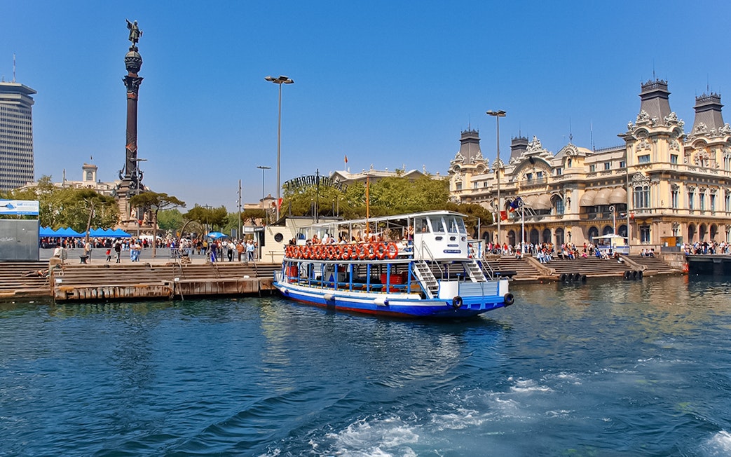 Las Golondrinas boat at Barcelona port with Columbus Monument in the background.