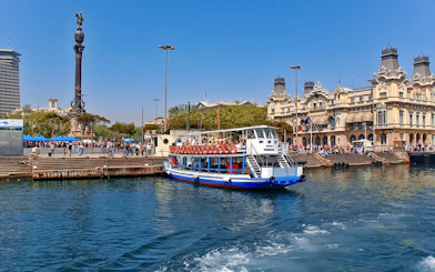 Las Golondrinas boat at Barcelona port with Columbus Monument in the background.
