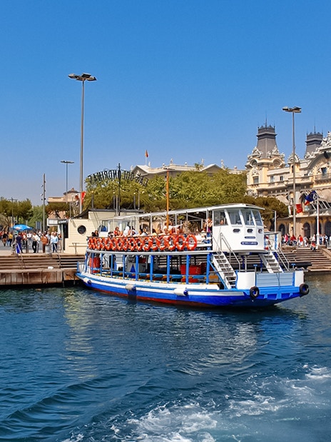 Las Golondrinas boat at Barcelona port with Columbus Monument in the background.