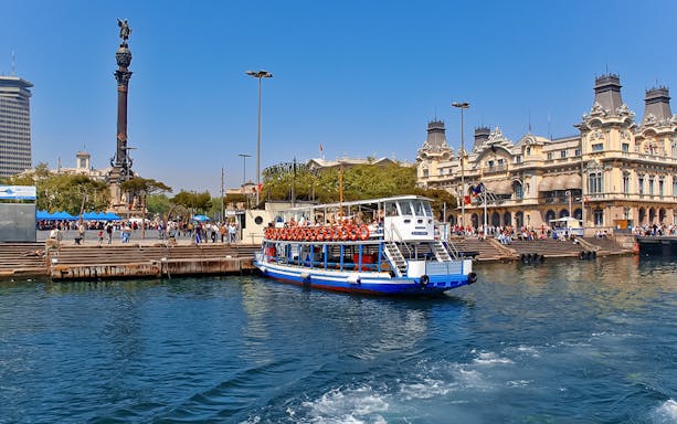 Las Golondrinas boat at Barcelona port with Columbus Monument in the background.