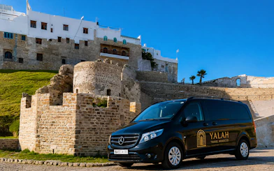 Tour van parked near historic Tangier Kasbah, Morocco.