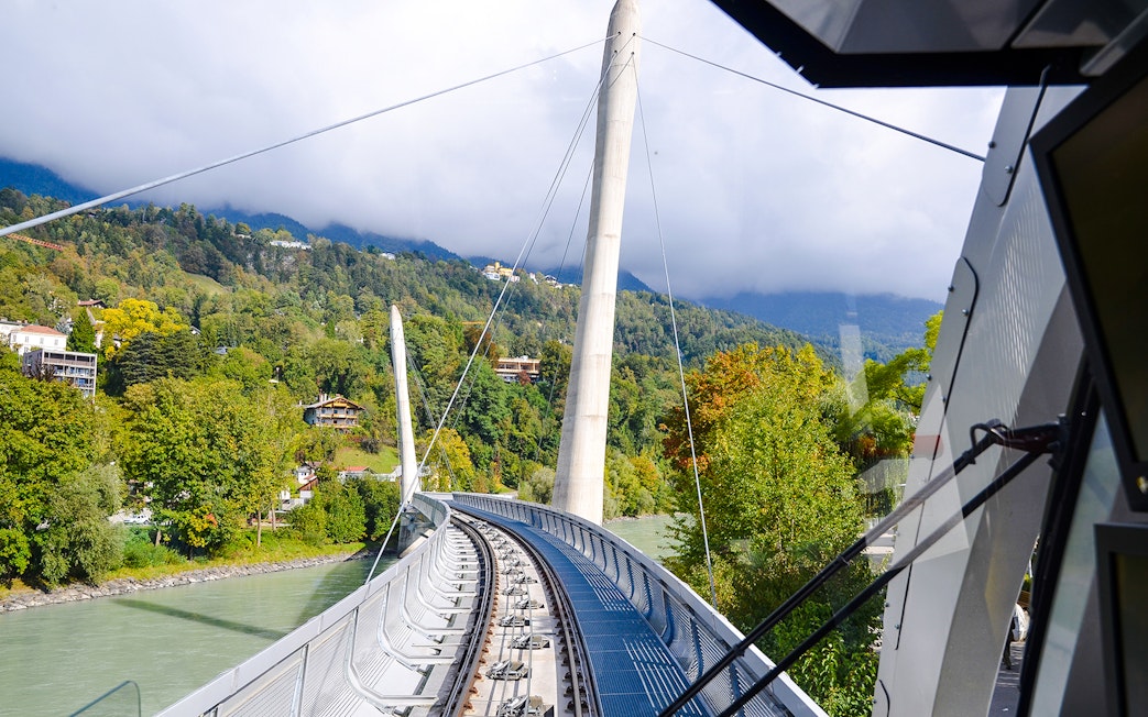 Hungerburg Funicular station view with tracks and lush green hills in Innsbruck, Austria.