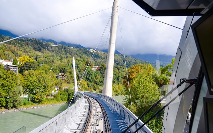 Hungerburg Funicular station view with tracks and lush green hills in Innsbruck, Austria.